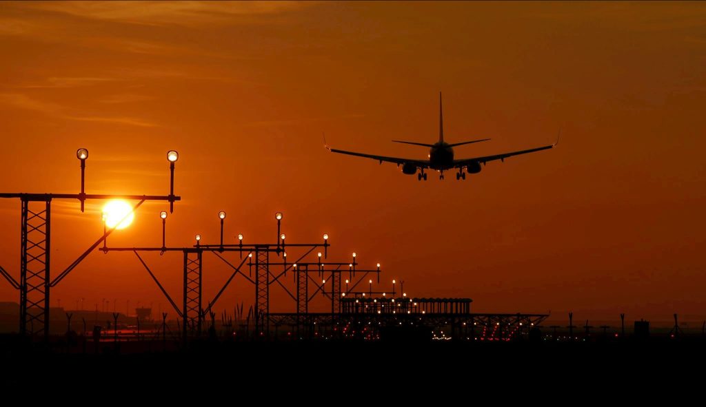 Plane touching down on a runway at dusk